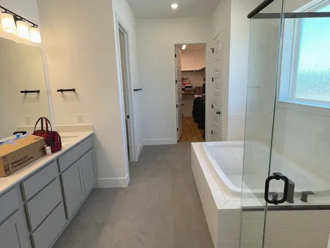 A cleaned bathroom after a Kempt clean, glass shower and soaking tub