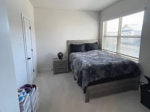 A tidy bedroom after a Kempt clean, bed made and blinds open